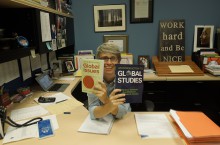 Ms. Anderson poses with textbooks that will be used in her Global Issues class this fall.