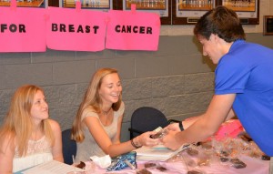Senior Rachel Nemmeth and Sophomore Megan Walsh help Sophomore Charlie "Boones" Stonceicpher decide what to get at the previous Baking For Breast Cancer bake sale.