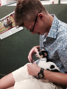Senior Mark Grenader enjoys spending time with the adorable puppies at Petland. Credit: Caroline Mills