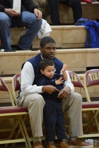 Head Coach Demetrius Smith steals a quiet moment with son Noah before the start of the Elite Eight game against Vidalia. Photo: Fred Assaf