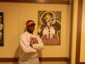 Thanks to his artistic prowess, Braylin Robinson has become a popular figure within the Pace community. Here, he stands with one of his portraits, which he named "Rude Boy". Photo by Jordan Harris.