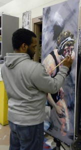 Donice Bloodworth works on a painting of a wrestle athlete for the Art Faculty Show opening February 17. Photo: Alyse Greenbaum