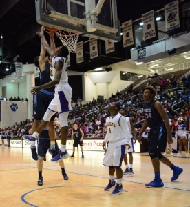 Sophomore Isaiah Kelly (blue) throws down a dunk over William Jarrell of Crawford County in the GHSA Final Four. Kelly had 20 points on the night. Photo: Fred Assaf
