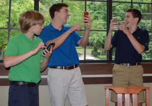 Freshmen Andrew Miller, Harris Greenbaum, and Robert Cushman (L to R), show off their rare Pokemon to each other. Photo: Amy Butler