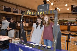 Seniors Lizabeth Frohwein and Laura Shelton attract students to their club.