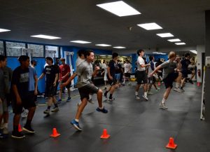 Athletes perform a variety of movement exercises to activate the nervous system and warm up the muscles before strength training. Photo: Marc Mitchell