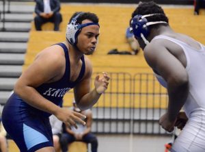 Junior Justin Morris sets himself to wrestle his opponent. Photo: Fred Assaf